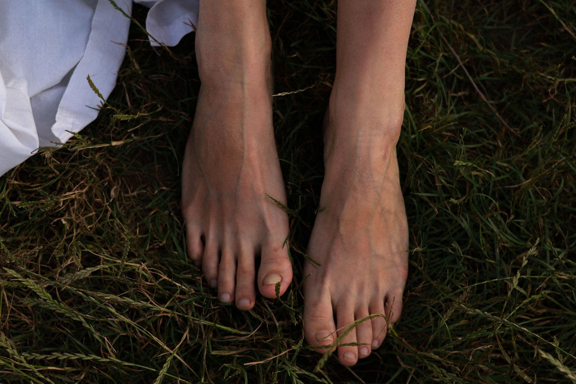 Femme pieds nus dans l'herbe, exercice d'ancrage en pleine nature