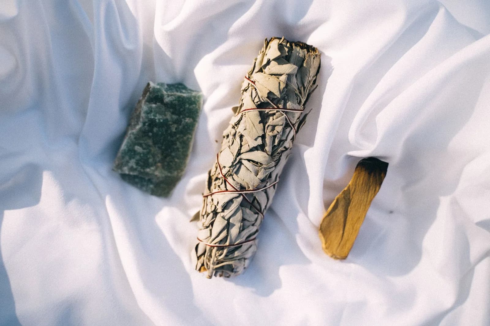Bâton de palo santo et sauge blanche posés sur une ardoise grise
